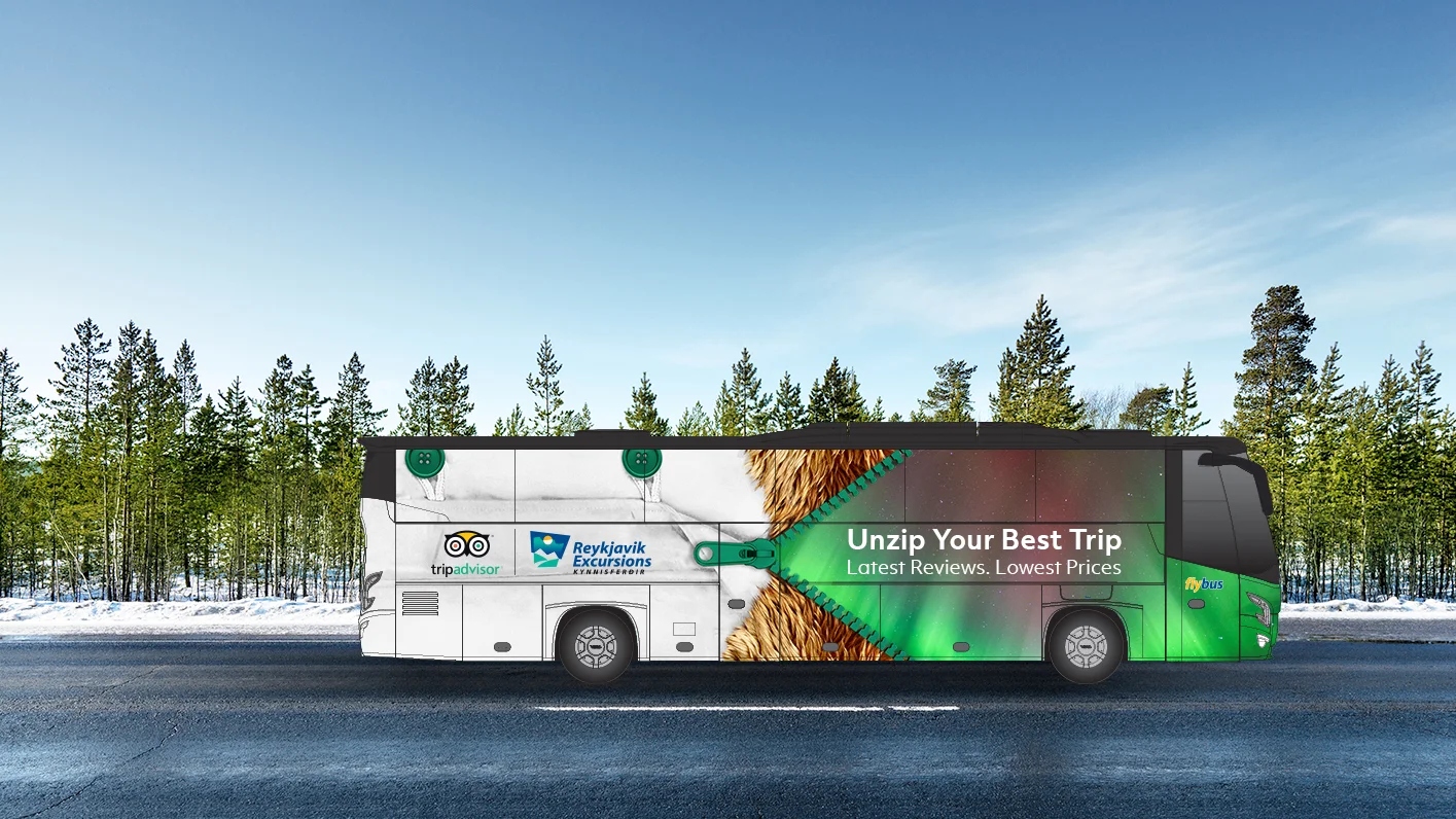 A coach bus wrapped in the Unleash Iceland campaign, a zipper opening onto northern lights with the line Unzip Your Best Trip, parked before a snowy pine forest